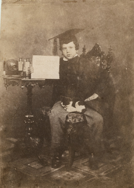 Young Graduate with Rare Lens, Stereo Viewer, Sign and a Cat in His Lap